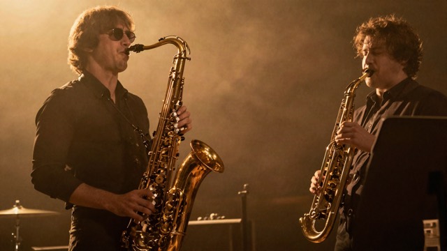 Saxophone and trumpet on a warmly lit stage