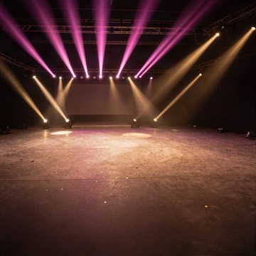 Pink and gold stage lights over an empty dance floor