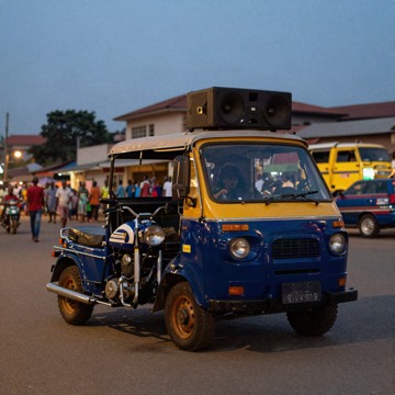 Motorcycle parked beside a large speaker on a city street at dusk