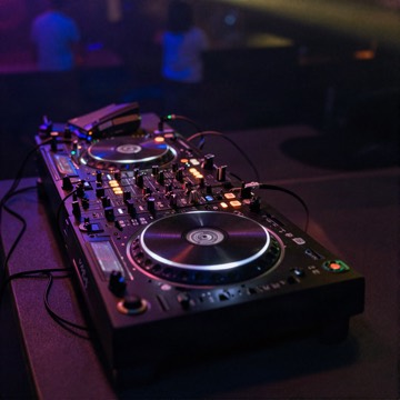 Neon-lit DJ booth with turntables