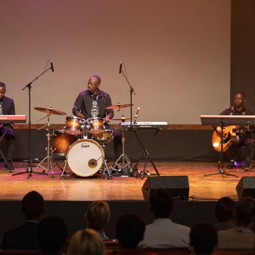 Gospel concert stage with drums and keyboard under warm lights