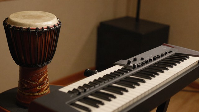 Talking drum next to a synthesizer in a studio